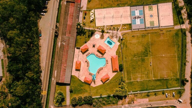 Vista aérea do Sabbia Club com piscinas, quadras e campo de futebol