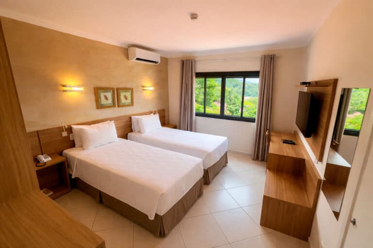 Apartamento com duas camas de solteiro e janela com vista para o verde