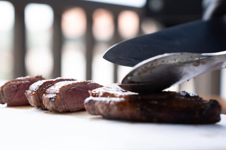 Carne de churrasco sendo fatiada na tábua