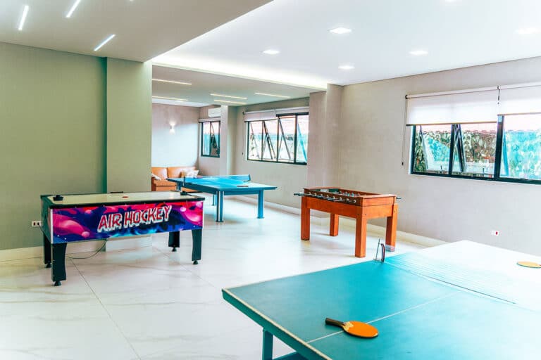 Salão de jogos com mesa de tênis de mesa e pebolim
